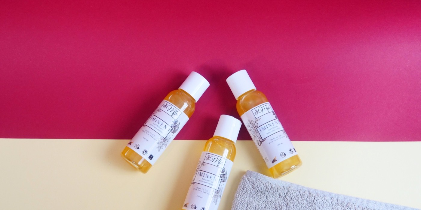 Bottles of Iminent Shampoo with caffeine extract